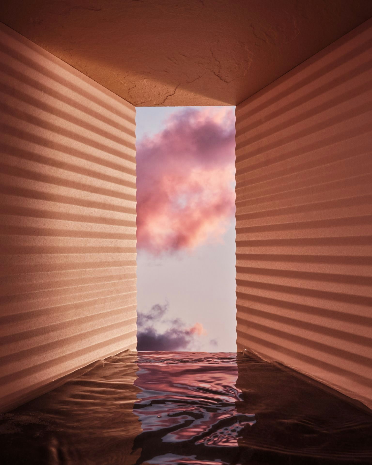 An abstract room with water, walls opening to the sky.