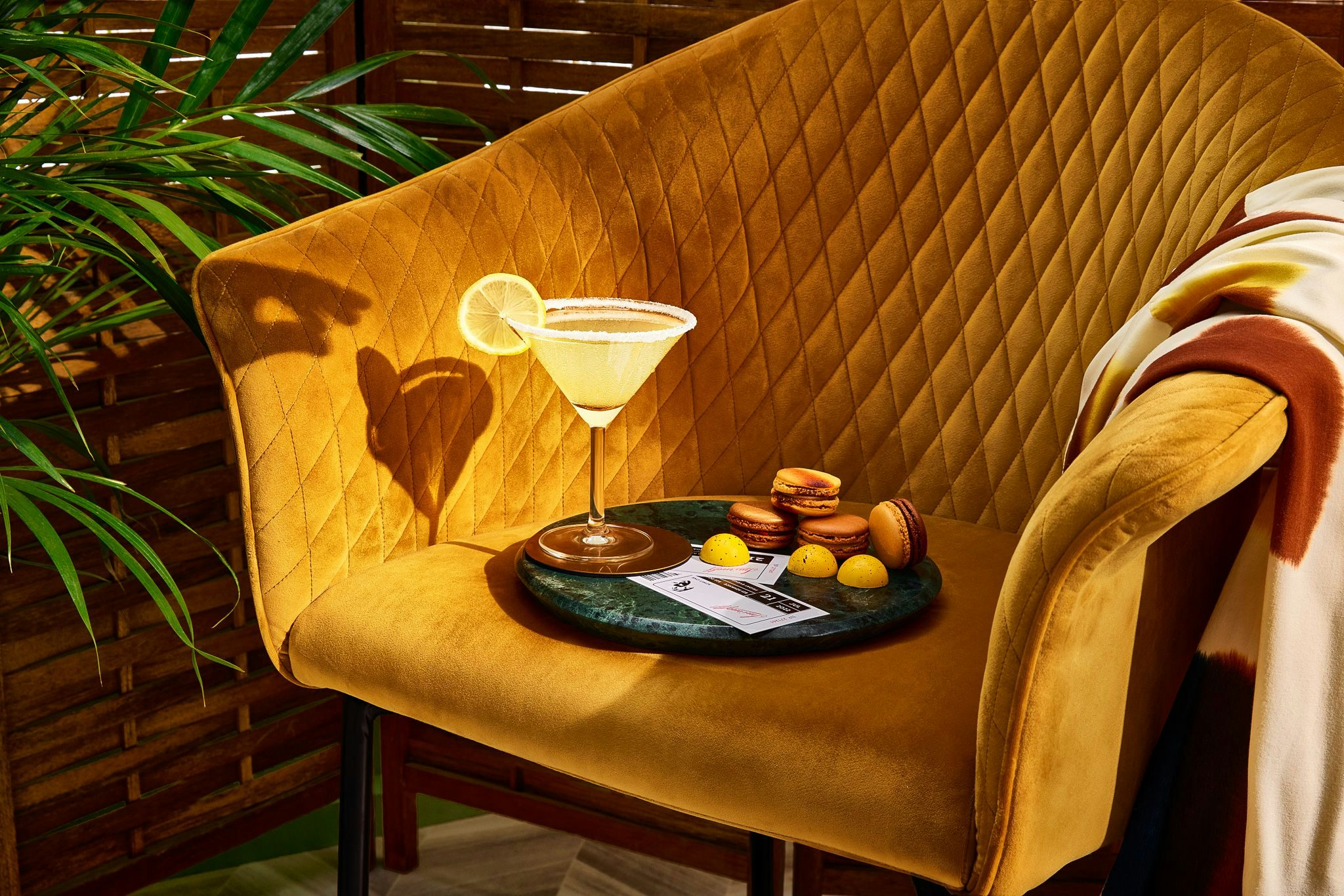 A cocktail on a tray with fruits, placed on an armchair.
